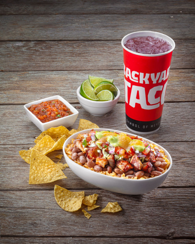  Loaded burrito bowl with chips, lime, and drink from Backyard Taco