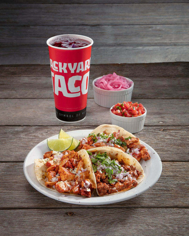 Tacos with salsa, lime, and drink from Backyard Taco