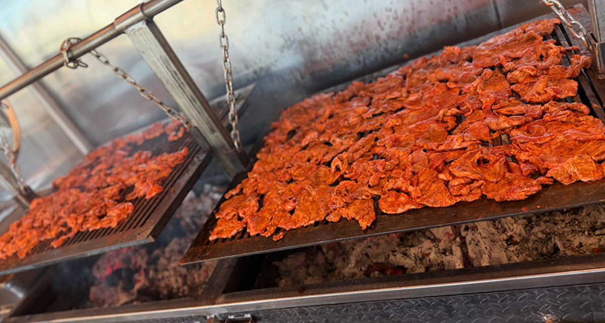 Mesquite grilled carne asada cooking over open flame for authentic Mexican food flavor
