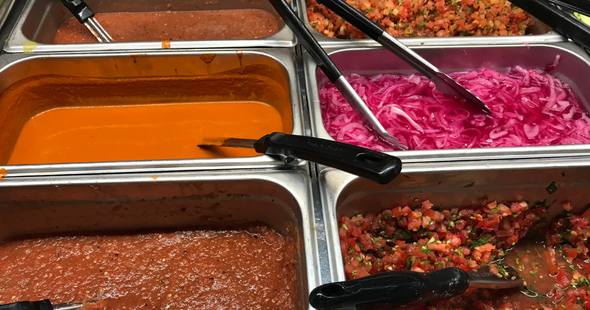 Backyard Taco salsa bar with fresh salsas, lime, cucumbers, radishes, and grilled vegetables